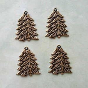 Pode incluir: Quatro pingentes de árvore de Natal de metal dourado antigo. Cada pingente apresenta um design detalhado e texturizado de um pinheiro com vários ramos.