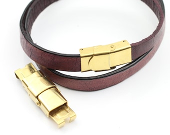 May include: A brown leather bracelet with a gold-tone clasp. The bracelet is double-wrapped and has a simple, elegant design.