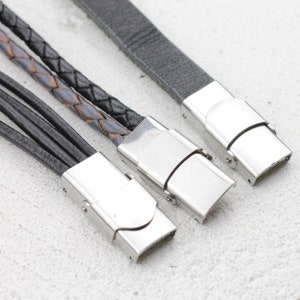 Puede incluir: Tres pulseras de cuero con cierres plateados. Las pulseras están trenzadas y tienen diferentes texturas.