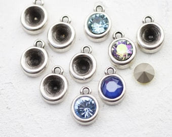 May include: Assortment of silver-toned metal pendant charms with various colored glass stones. The charms feature a round, concave design with a small loop at the top for attaching to jewelry.