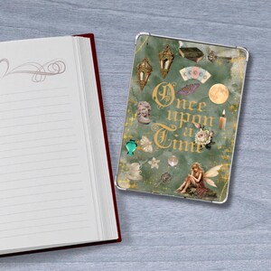 Pode incluir: Um diário de capa dura com páginas pautadas e lombada vermelha está ao lado de uma capa de tablet. A capa do tablet tem um fundo verde com as palavras "Once upon a Time" e várias ilustrações.