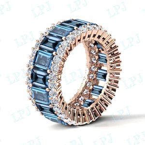 Puede incluir: Un anillo de banda de oro rosa con una doble fila de topacio azul y diamantes blancos. El anillo está engastado en garras y tiene un acabado pulido.