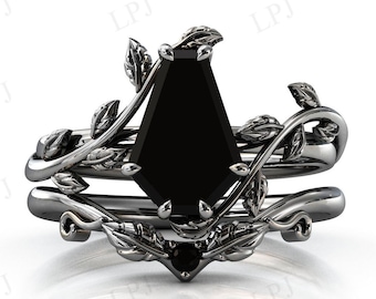 May include: A black diamond engagement ring set with a black metal band and leaf accents. The ring features a large, octagonal-shaped black diamond.