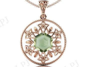 Può includere: Una collana con un ciondolo in oro rosa con una pietra preziosa verde incastonata in un delicato e intricato design floreale.