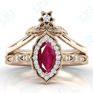 May include: A gold ring set with a large, marquise-shaped ruby surrounded by smaller diamonds. The ring has a delicate floral design and a smaller band with diamond accents.