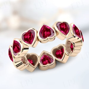 Peut inclure: Une bague en or avec une rangée de pierres précieuses en forme de cœur en rubis.