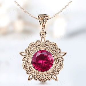 May include: A gold pendant necklace featuring a large red gemstone set in a filigree design.