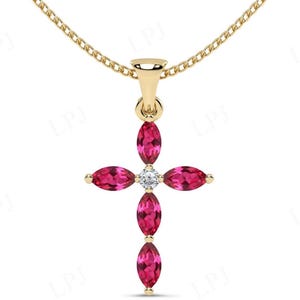 Pode incluir: Um colar com pingente dourado com um design de cruz. A cruz é adornada com pedras preciosas rosa vibrantes, com corte marquesa, e uma pedra preciosa central, redonda e transparente. A corrente do colar é delicada e dourada.