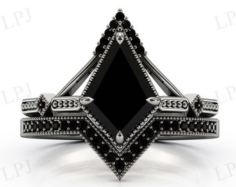 May include: A black and silver engagement ring set. The main ring features a large, square-cut black gemstone, surrounded by smaller black stones and silver detailing. The matching band is also adorned with black stones.