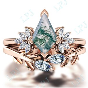 Puede incluir: Un anillo de oro rosa engastado con una piedra de ágata verde y diamantes transparentes en forma de marquesa. El anillo presenta un delicado diseño floral con hojas y ramas.
