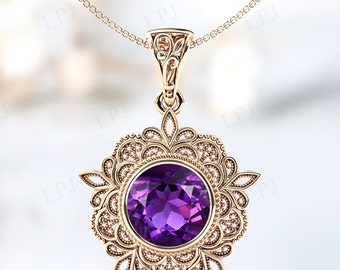 May include: A delicate gold pendant necklace with a large, round, purple amethyst gemstone set in a filigree design.