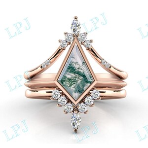 Puede incluir: Un anillo de oro rosa engastado con una piedra de ágata verde musgo en forma geométrica. El anillo está adornado con pequeños diamantes transparentes y tiene un diseño delicado e intrincado.