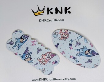 May include: Two blue and pink patterned hair clips featuring a cartoon dog wearing a party hat. The clips are on a white background with the text "KNK Craft Room" and "www.KNK Craft Room.etsy.com".