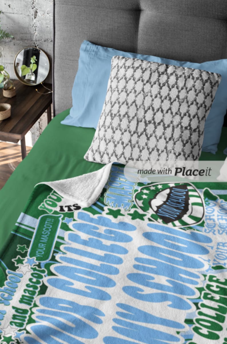 Peut inclure: Une couverture blanche et bleue sur le th&egrave;me du coll&egrave;ge avec le texte "YOUR SCHOOL AND MASCOT!!" et "YOUR COLLEGE". La couverture est sur un lit vert avec un oreiller &agrave; motifs et des oreillers bleus.