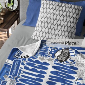 Peut inclure: Une couverture bleue et blanche sur le th&egrave;me du coll&egrave;ge avec le texte "YOUR SCHOOL" et "COLLEGE" dans une police stylis&eacute;e. La couverture pr&eacute;sente un motif d'&eacute;toile et de bouclier. Un oreiller &agrave; motifs et des oreillers bleus reposent sur un lit gris.