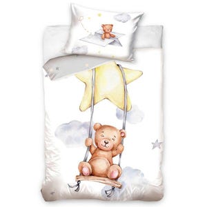 Puede incluir: Un juego de cama de acuarela blanco y gris con un oso de peluche marrón columpiándose de una estrella amarilla. El oso de peluche lleva una pajarita azul y está rodeado de nubes blancas.