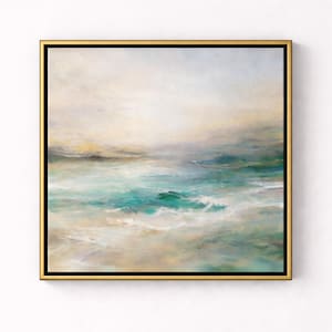 May include: Abstract ocean landscape painting in shades of teal, turquoise, and beige. The artwork features a square canvas with a gold frame. The painting depicts waves and a cloudy sky, evoking a sense of tranquility.