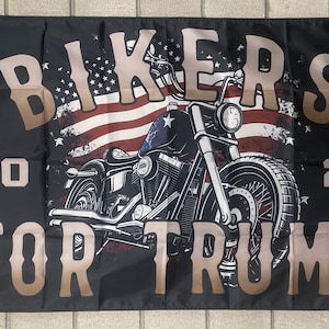 May include: Black flag with a motorcycle graphic and the text "Bikers for Trump" in brown lettering. The motorcycle is in front of a distressed American flag graphic. The numbers "20" and "24" are on either side of the motorcycle.
