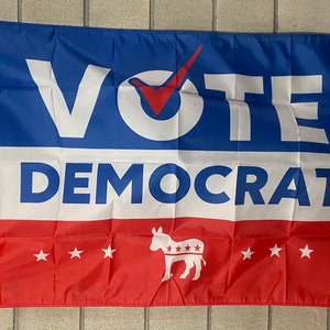 May include: A blue, white, and red political flag with the text "VOTE DEMOCRAT" and a donkey with stars on it.