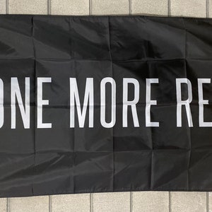 May include: Black flag with white text that reads "ONE MORE REP".