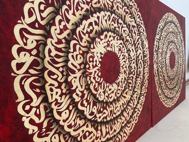 Puede incluir: Dos lienzos rojos con caligraf&iacute;a dorada en forma circular. La caligraf&iacute;a est&aacute; en escritura &aacute;rabe.
