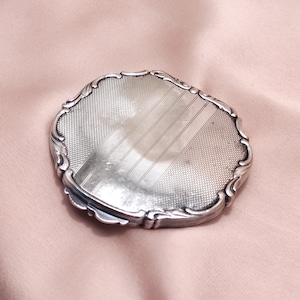 Elegante antico portacipria compatto Art Déco in alpaca argento inciso con linee geometriche lavorate a macchina specchio per il trucco vintage comò in alpacca c. 1920