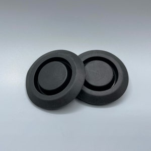 Può includere: Due passacavi in ​​gomma nera con un anello centrale rialzato.