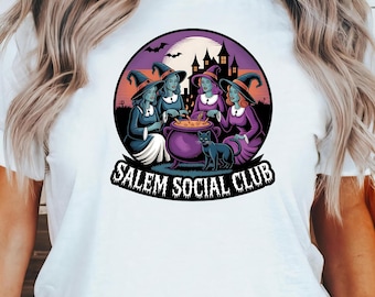 May include: White t-shirt featuring a circular graphic of four witches gathered around a cauldron, with a black cat and the text "Salem Social Club." The graphic is set against a purple night sky with bats and a haunted house.