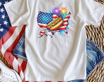 May include: White t-shirt with a graphic of a hot dog on top of a watercolor American flag in the shape of the United States. Fireworks are in the background.