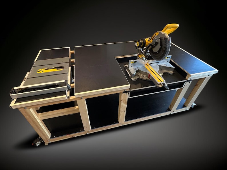 K&ouml;nnte beinhalten: Ein gro&szlig;er, ma&szlig;gefertigter Holzbearbeitungsplatz mit schwarzer Tischplatte und einer gelb-silbernen Gehrungss&auml;ge. Der Arbeitsplatz hat eine Tischkreiss&auml;ge und wird von einem hellen Holzrahmen getragen. Der Arbeitsplatz ist auf R&auml;dern.