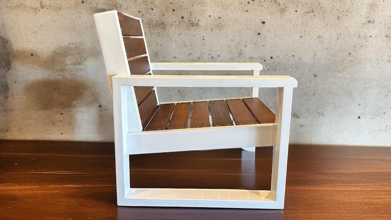 May include: A small, white wooden chair with a slatted seat and backrest made of brown wood. The chair has a simple, modern design and is suitable for indoor or outdoor use.