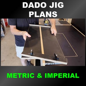 Op de afbeelding: Zwarte dado-malplannen met de tekst "DADO JIG PLANS" in het wit. De tekst "METRIC & IMPERIAL" is groen. De mal wordt door een persoon vastgehouden. De mal heeft een zwart oppervlak met een beige streep in het midden.