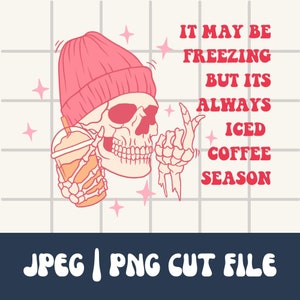 May include: A pink cartoon skull wearing a pink beanie holds a cup of iced coffee. The text reads "It may be freezing but it's always iced coffee season."
