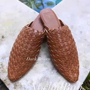 K&ouml;nnte beinhalten: Ein Paar dunkelbraune, geflochtene Lederschlappen. Die Schlappen haben eine spitze Zehenpartie und ein geflochtenes Design. Der Text "Dark Brown" und "N ochia Bali" ist im Bild zu sehen.