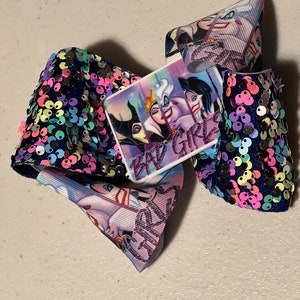 May include: A purple, blue, and white bow with a square patch featuring the Disney villains Maleficent, Ursula, and Cruella de Vil. The patch has the text "Bad Girls" on it. The bow is covered in iridescent sequins.