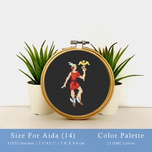 May include: A cross-stitch pattern of a person in a red tunic holding a golden staff with an eagle on top. The pattern is framed in a wooden hoop and is on black Aida cloth. The pattern is 32 stitches wide by 52 stitches high, and measures 2.3 inches by 3.7 inches, or 5.8 centimeters by 9.4 centimeters.