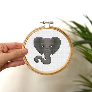 May include: A gray elephant head cross-stitch pattern in a wooden embroidery hoop.