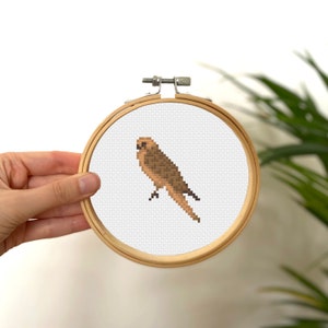 May include: A brown bird cross-stitch pattern in a wooden embroidery hoop.