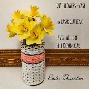 Op de afbeelding: DIY Bloemen + Vaas voor lasersnijden. SVG, AI, DXF Bestand Download. Paasdecoratie. Een boeket gele narcissen in een witte en roze geweven vaas.