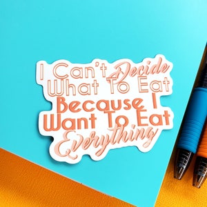May include: A white sticker with pink text that reads "I can't decide what to eat because I want to eat everything".