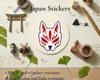 May include: A sticker featuring a white and red fox mask design centered on a circular background. The image includes text reading Japan Stickers, Water and weather resistant, Long-lasting and fade-resistant, and Multiple Sizes.