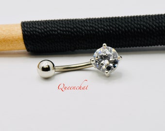 May include: Silver belly button ring with a clear round gem in the center.