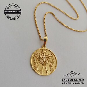 May include: Gold-plated 925 sterling silver necklace with a circular pendant. The pendant features a detailed moth design, a crescent moon, and leafy accents. The chain is a delicate box chain. The text "BEST QUALITY" and "LAND OF SILVER" are visible.