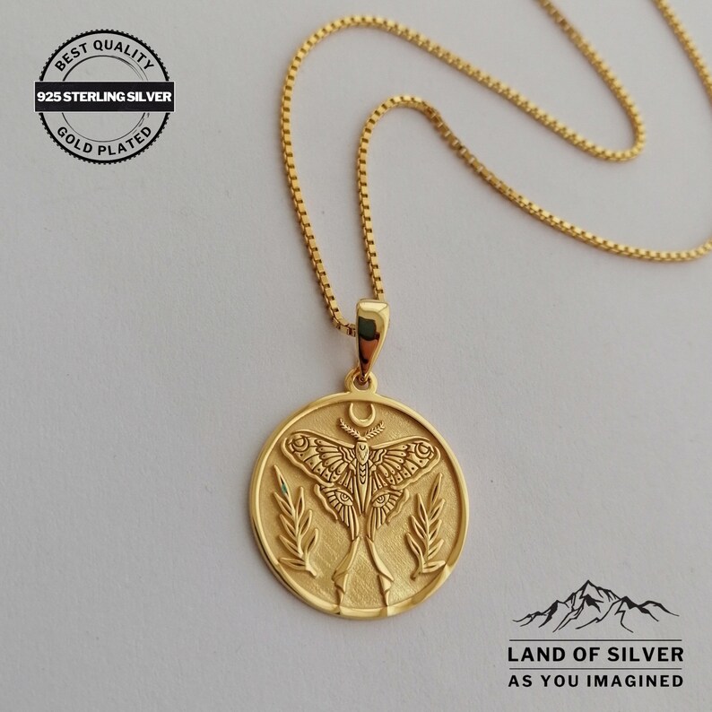 May include: Gold-plated 925 sterling silver necklace with a circular pendant. The pendant features a detailed moth design, a crescent moon, and leafy accents. The chain is a delicate box chain. The text "BEST QUALITY" and "LAND OF SILVER" are visible.