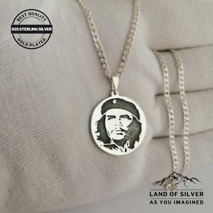 May include: Silver necklace with a round pendant featuring a black and white image of Che Guevara. The pendant is on a silver curb chain. The necklace is labeled "925 Sterling Silver Gold Plated" and "Best Quality".