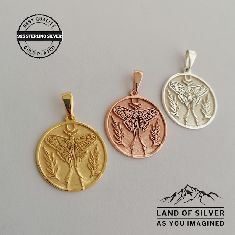 May include: Three gold-plated and silver pendants featuring a moth design. Each circular pendant has a detailed moth illustration, a crescent moon, and leaf accents. The pendants are labelled "925 Sterling Silver" and "Gold Plated". The brand name "Land of Silver" is also visible.