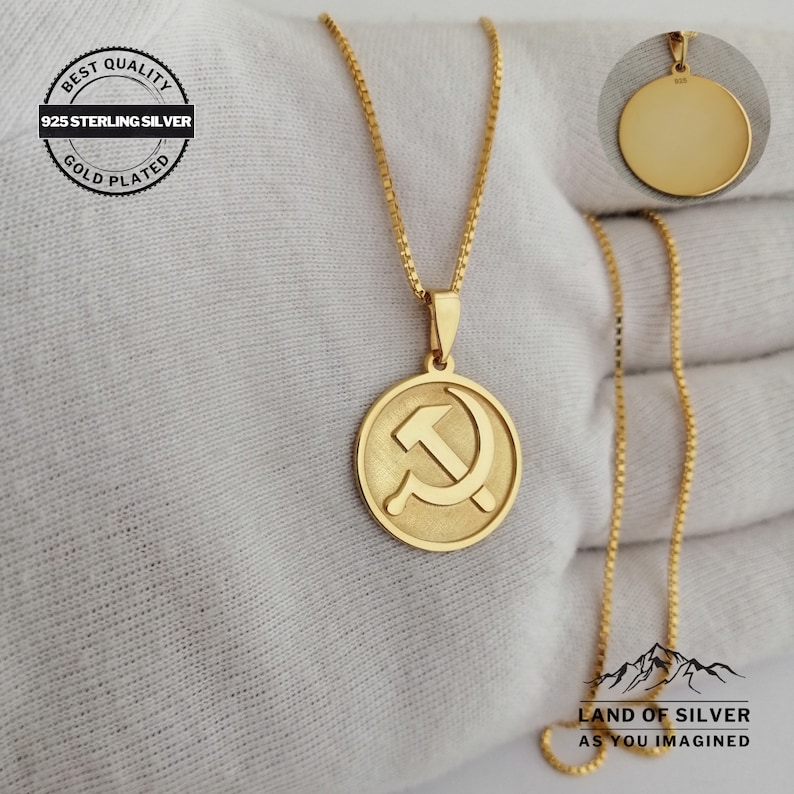 May include: Gold plated 925 sterling silver necklace with a round pendant featuring a hammer and sickle design. The pendant is on a delicate chain.