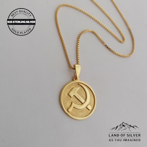 May include: Gold-plated 925 sterling silver necklace with a round pendant featuring a hammer and sickle symbol. The necklace is on a white background. "Best Quality 925 Sterling Silver Gold Plated" is written on a circular label in the top left corner of the image.