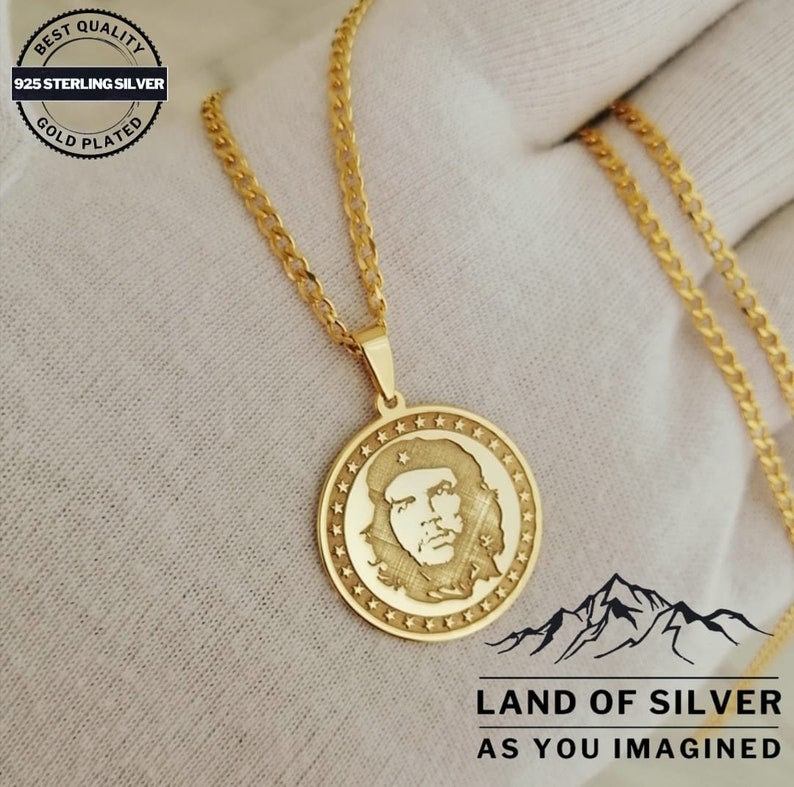 May include: Gold-plated 925 sterling silver chain necklace with a round pendant featuring a profile image of Che Guevara. The pendant is surrounded by a circle of stars. The text "LAND OF SILVER AS YOU IMAGINED" is printed below the pendant.