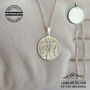 May include: A silver pendant necklace with a detailed moth design within a circular frame, hanging from a fine chain. The pendant features a crescent moon above the moth. The image includes text: "BEST QUALITY 925 STERLING SILVER GOLD PLATED".